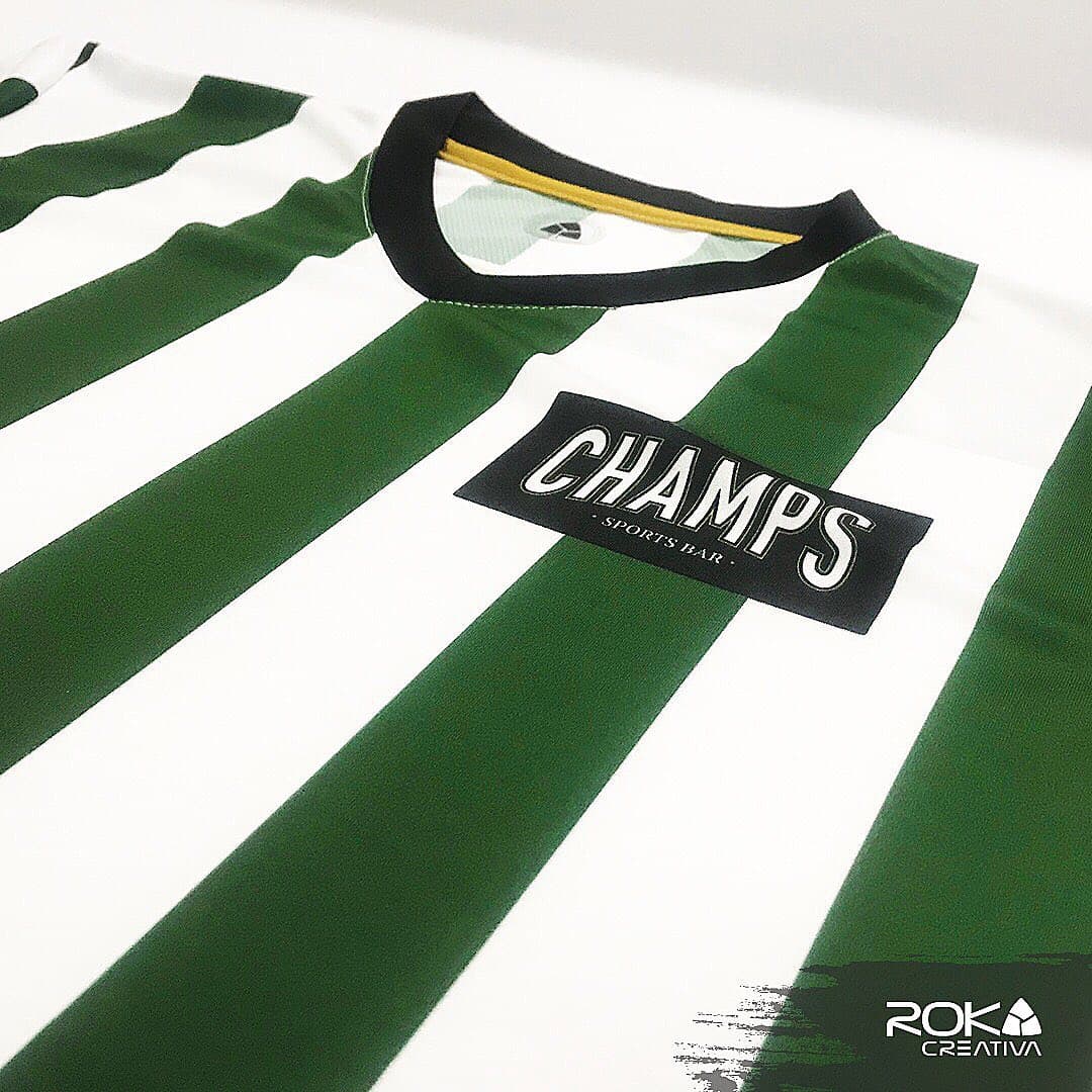 Detalle del cuello de pico y el parche Champs Sports Bar cosido en el uniforme