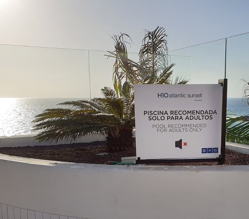 Cartel de señalética de piscina solo para adultos del H10 Atlantic Sunset con el mar de fondo