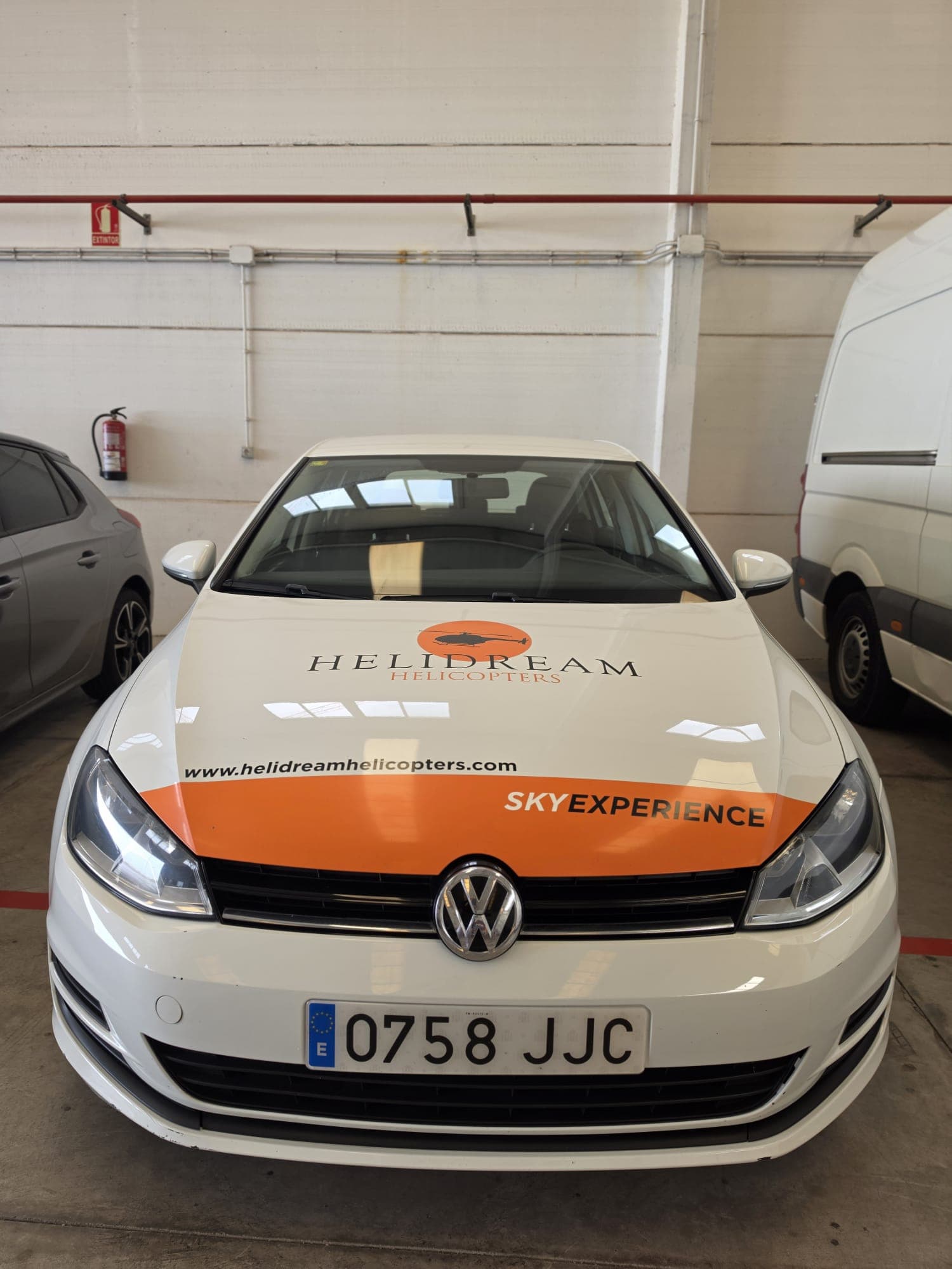 Capó del coche corporativo rotulado con el logo Helidream y la franja Sky Experience