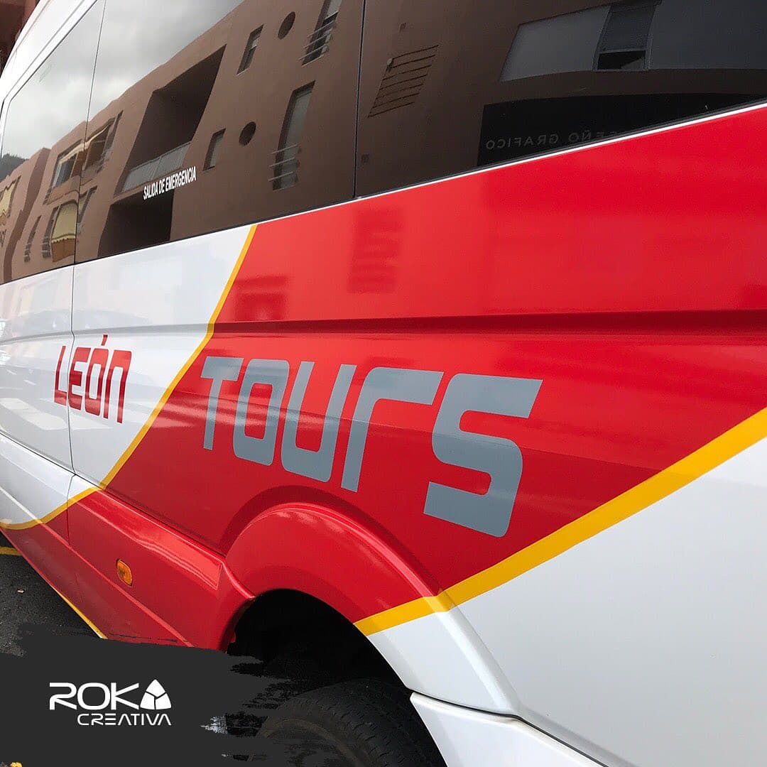 Detalle del lateral del minibús de León Tours con las franjas y el logotipo en vinilo