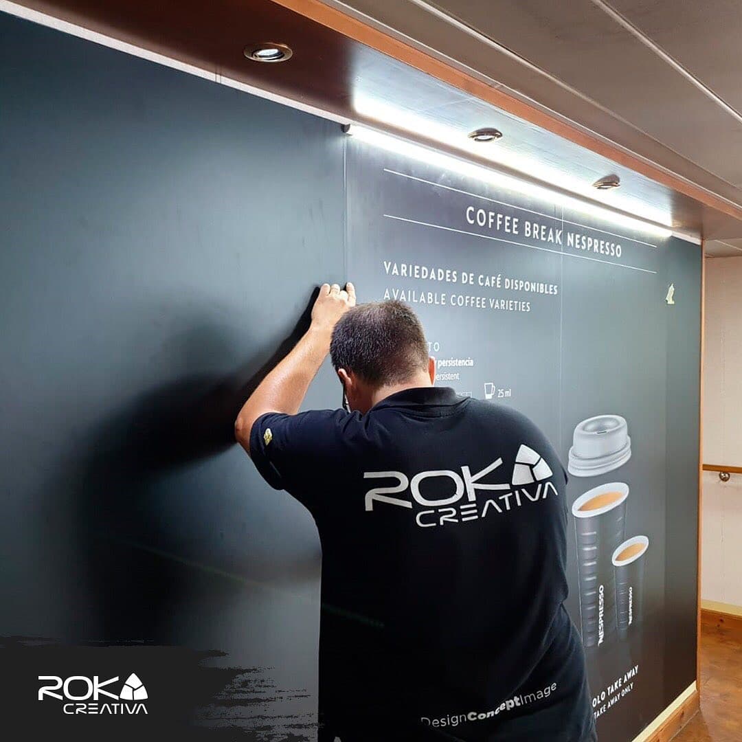 Instalador de Roka Creativa aplicando el vinilo del mural a bordo