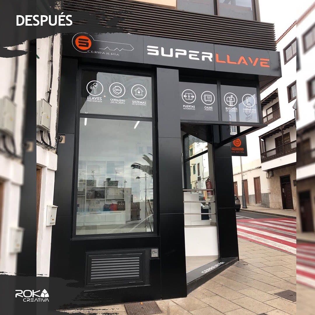 Fachada comercial renovada de la cerrajería Super Llave en negro con rótulo e iconos de servicios